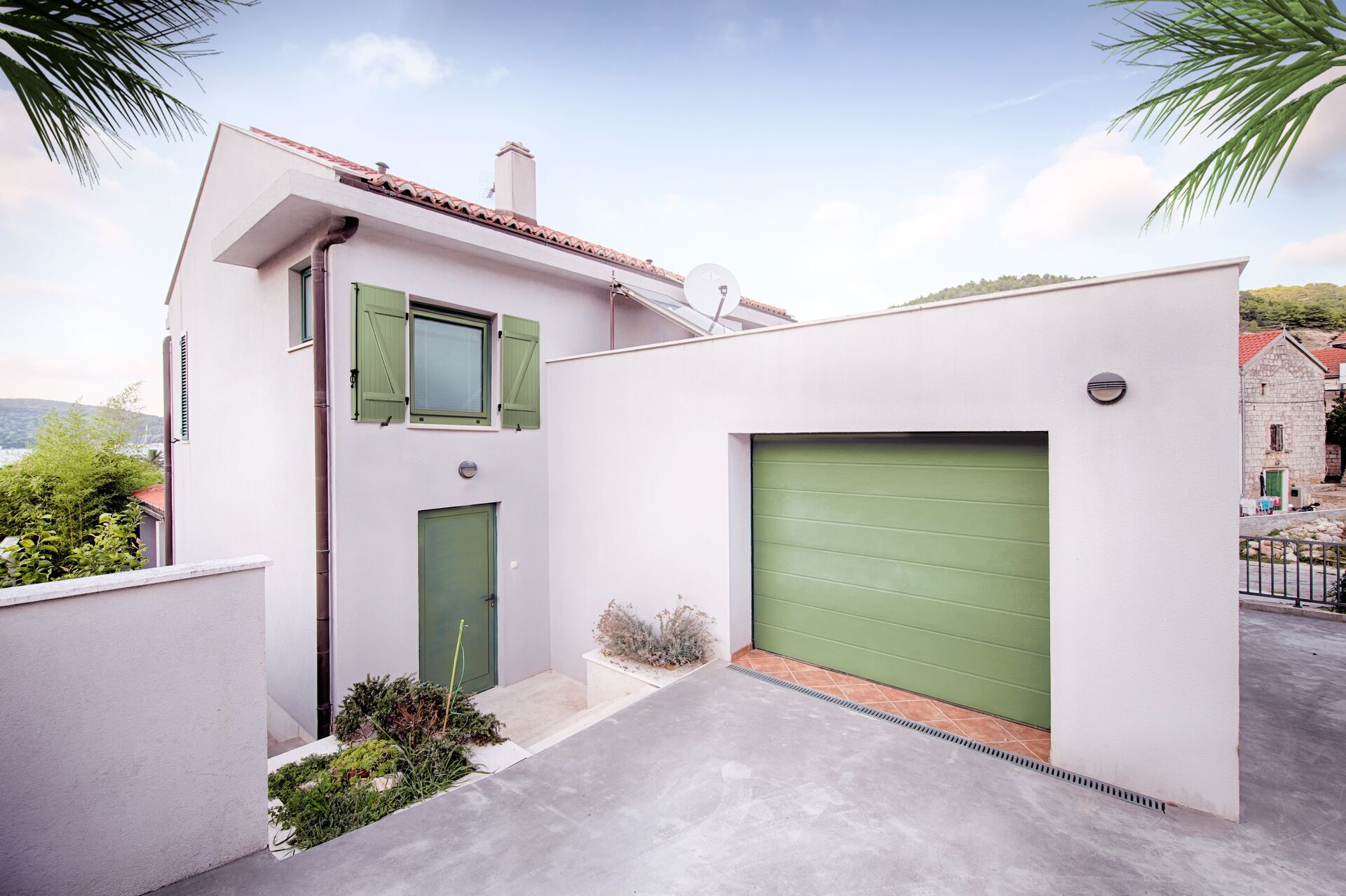 Volet-battant-pvc-lames-clipsees-collees-24-mm-et-porte-de-garage-sectionnelle-a-refoulement-plafond-en-acier-isole-motorisee-standard-min